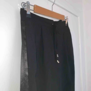  - Svarta kostymbyxor med satin revor! Skitsnygga, jättebra skick. Storlek 38 ungefär. Sköna men snygga.