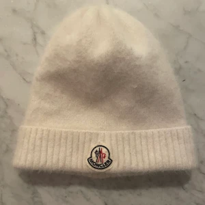 Moncler mössa - En jättefin äkta Moncler mössa. Går att vika upp kanten mer om man vill. Så mjuk och skön, gjort av Angora. Hör av er för mer bilder eller frågor💕 (nypris ca 2000kr)