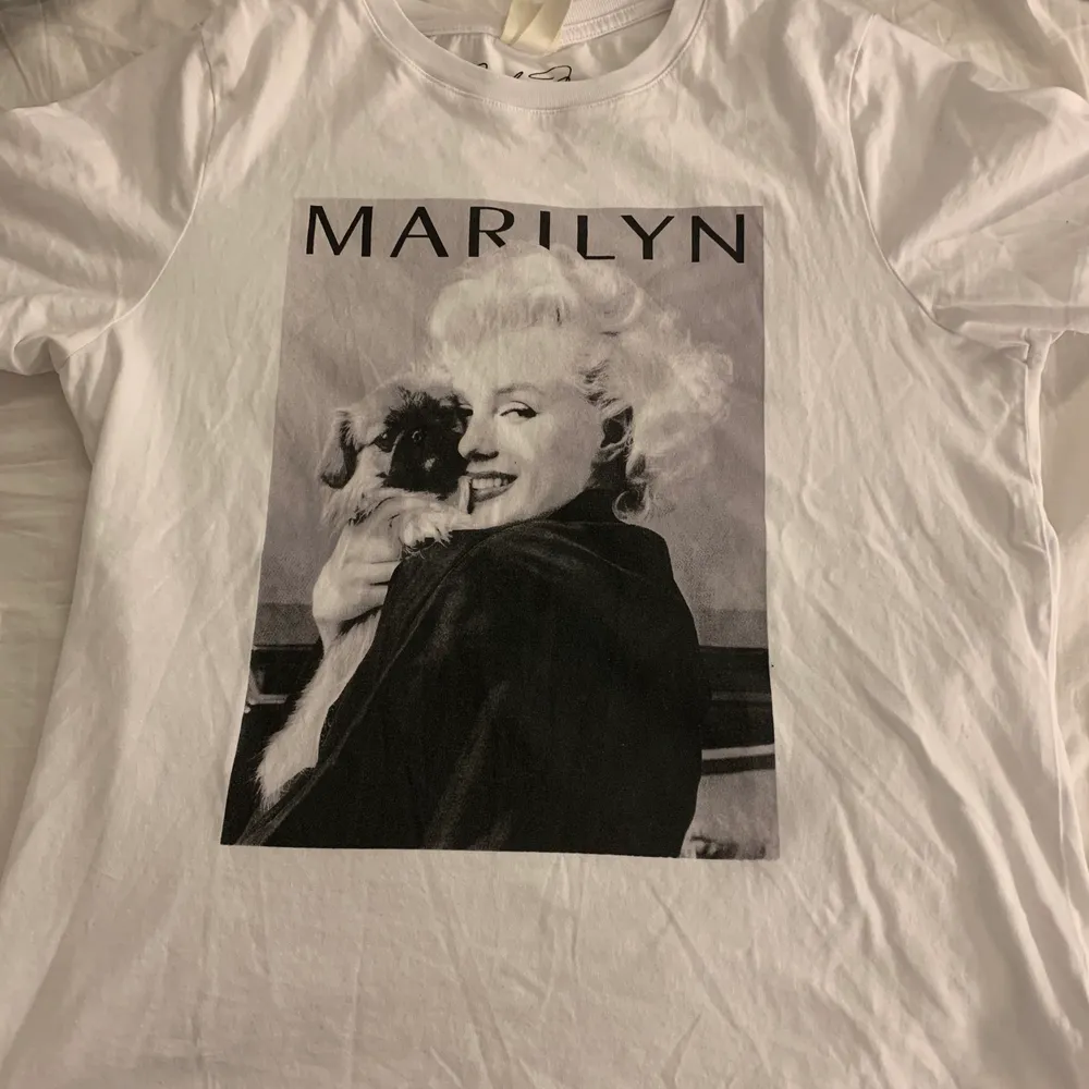En jättefin Marilyn Monroe T-shirt från H&M. Använd fåtal gånger. Kommer ej till användning och därför säljer jag den:) priset är ej skrivet i sten!! vill gärna sälja alla kläder jag lagt ut så kika in min profil, massa fina kläder!. T-shirts.