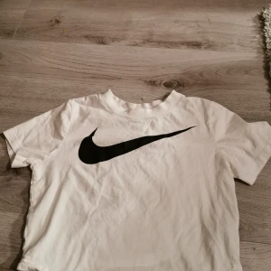 Nike crop top - Nike crop top storlek small. Jättesnygg passform med lite högre hals/urringning och en kort modell. Fungerar både till träning och vardags. Lite tjockare t-shirt material för snygg passform! 