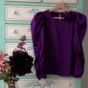 En lila blus från Zara, storlek M.  - En vacker och elegant blus. Blusen har fantastiskt vackra detaljer både på axlarna och armarna, som ni ser på bilden. Den är väldigt lyxig. Dessutom har den varit använd vid få tillfällen. Som första pris ligger den på 90kr + frakt. Skriv gärna bud i kommentarsfältet. 