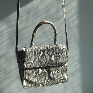 Väska ormskinnsmönster - Svinball väska som är i ett läderliknande material med ormskinnsmönster