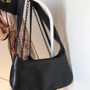 svart 2000s väska - en svart, söt väska som passar perfekt under armen till varenda outfit ☺️ älskar den så mycket, men behöver pengarna. köpt secondhand, men i väldigt bra skick! möts i västerås, annars står du för frakten ❤️ 