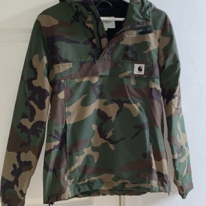 Pullover Jacka från Carhartt - Pullover Jacka från Carhartt. Storlek S Jackan har en stor ficka på magen. Köpt på Junkyard för 1700kr, säljes för 700kr. Använd många gånger, är i gott skick.