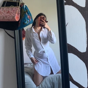 Skjort Klänning  - Vit skjorta klänning med skärpi storlek S. Aldrig använd. Kan även användas som beach cover up. Skriv för mer info och bilder. Tar endast swish och köparen står för frakt.