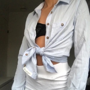 Ljusblå skjorta  - Ljusblå H&M skjorta med blåa tyglappar vid armbågarna. Använd ett fåtal gånger, köpare står för fraktkostnad.