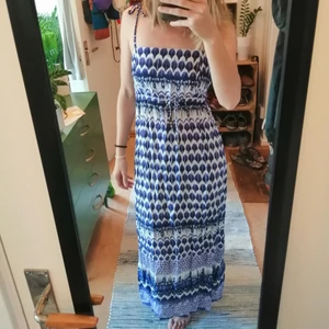 Maxiklänning från indiska  - Skön maxiklänning I härliga färger med knytning under bysten och knytbara axelband för finjustering av size. Använd 2 gånger. Den slutar ca 1 och 1/2 decimeter över marken på mig som är 172.