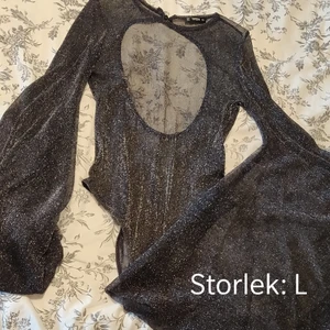 Bodysuit - Svart genomskinlig jätteglittrig bodysuit med stora ärmar och öppen rygg. Använd vid ett tillfälle, så bra skick! 🎉 Kika gärna in vad mer jag säljer! 💞