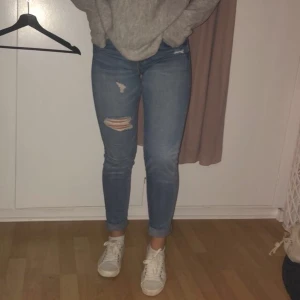 Hm jeans - Ett par blåa lite slitna jeans ifrån hm, jeansen är skinny och low Waist. Ganska långa i benen