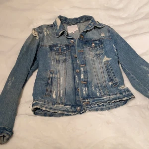 ”Sliten” Jeansjacka - Riven och sliten jeansjacka, köpt från Zara, köpt för två år sen men använder ej. Köpt för 399 kr.