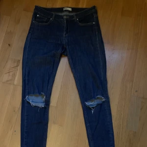 Slitna jeans - Lågmidjade jeans från Gina Tricot med slitningar på knänan. Storlek 40 men tror de passar bra på 38 också. Orginalpris 500kr men jag säljer dem för 100kr + frakt🌶