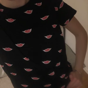 Strandivarius tshirt med ”läpptryck” - Säljer denna tshirt från Stradivarius med tryck av massa röda läppar! As cool och är använd några få gånger (jättebra skick)! Köpt för ca 1,5 år sedan och säljer nu för 40kr + eventuell frakt (kan mötas i Stockholm). Pris kan diskuteras så buda! 🤍🤍