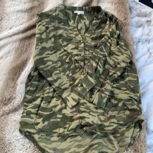  Skjorta  - Säljer min näst intill oanvända skjorta med militärmönster som inte riktigt är min stil längre, mycket fint skick. Står storlek S men passar även XS om man vill att den ska sitta lite oversized. Funkar även bra med passform som Medium.