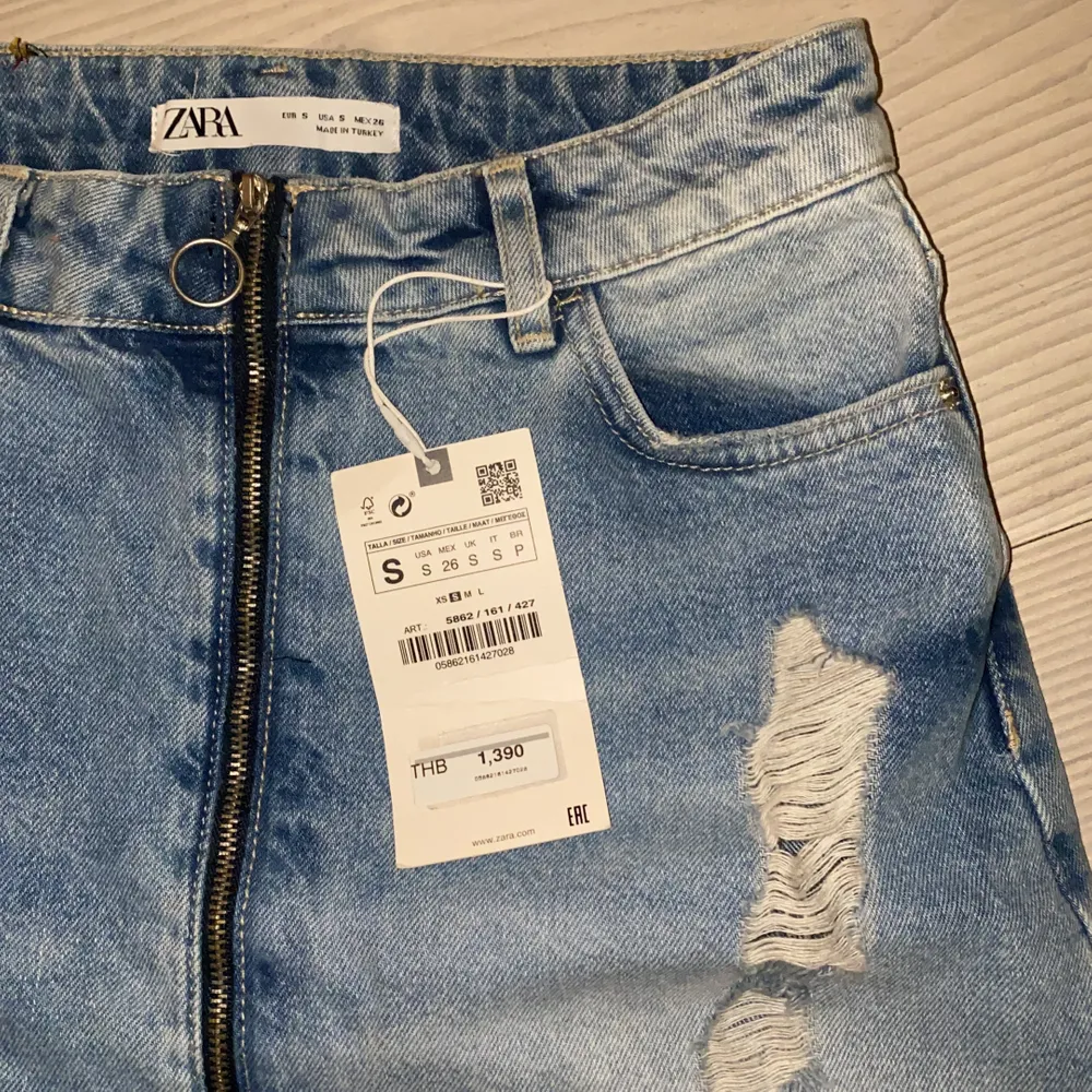 Ripped Jeans kjol från Zara med dragkedja längst hela framsidan, aldrig använda, köpt dom i Thailand därför är prislappen i thai valuta, original pris är c 350-400kr. Kjolar.