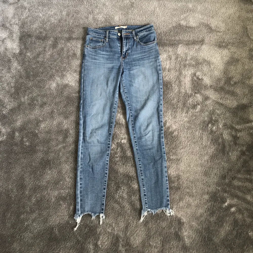 Säljer ett par blå Levis jeans i modell 721 med slitningar nertill. Använda men i bra skick. Storlek 26. Skriv för fler bilder. . Jeans & Byxor.