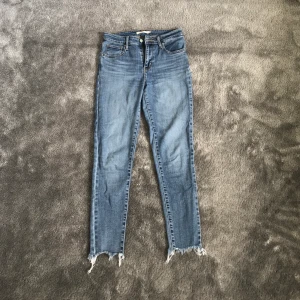 Levis jeans 721 - Säljer ett par blå Levis jeans i modell 721 med slitningar nertill. Använda men i bra skick. Storlek 26. Skriv för fler bilder. 
