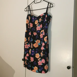 Blommig klänning stl 36. - Söt kort bomullsklänning med färgglada blommor. Sparsamt använd. Mycket fint skick. Mottagare står för frakt. 