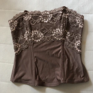 Corsette/corset - Super snygg corset i brun färg med lace. Piffar UP en outfit väldigt lätt! Finns stretch i❤️ PRIS går att diskutera☺️