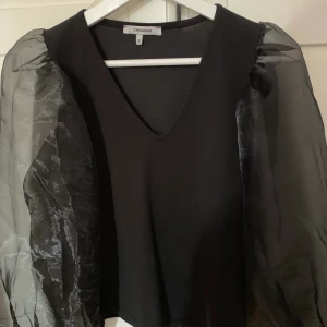 Svart blus - Svart blus med puffärmar. Tyget på själva tröjan är bomulls tyg. Köpt på chiquelle för 400kr. Andvänd 1 gång. Köparen står för frakt. 