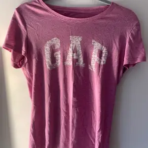 En snygg lila gap t-shirt som är köpt i USA den är använd den ända skadan den har är där det ska stå storlek men den är äkta super härlig färg