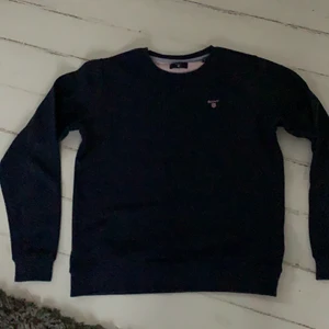 Gant tröja strl 170 - Marinblå gant tröja med rosa märke. Använd några fåtal gånger så den är i otroligt bra skick. Strl 170. Hör gärna av dig vid intresse, pris kan diskuteras!