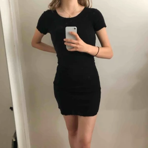  - Basic, svart klänning med ”lettuce”-fållar! Frakt inräknad i priset.