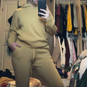  - Stickat set, säljer båda för 179kr(inkl frakt) i senapsgul färg.  De är inte utsvängda nertill utan har samma tyg som vid handleden nertill. Är 160 och den satt perfekt. Byxorna har snörning så man kan spänna åt. Tröjan har luva