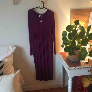  - Superfin, helt oanvänd mörklila klänning med sprund på ena sidan. Skickar eller möts upp i Stockholm. Köparen står för frakt. Nypris 690kr
