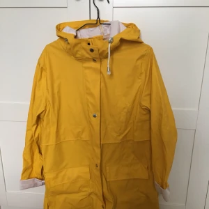  - Gul regnkappa från BikBok i strl M. Knappt använd. Möts upp i Stockholm eller skickas mot fraktkostnad. 