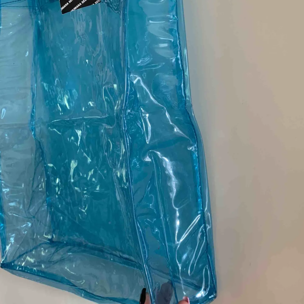En blå genomskinlig väska som är köpt på humana.                  Storlek: 37 cm hög och 30 cm bred. Säljer för 80kr ink frakt❤️. Väskor.