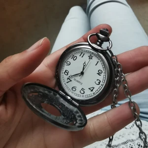 Modernt fickur - Modern fickur halsband i mörkmetall med ett fina mönster på baksidan. Klockans fungerar, men batteriet är slut. Trotts det är den är mycket vacker som smycke. Längden på kedjehalsbandet är ganska ca lite över 20 cm. Pm för exakta mått och frågor ❤️