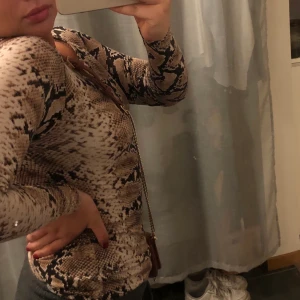 Långärmad tröja med Snakeskin mönster  - Långärmad tröja som framhäver kroppens fina former. Storlek xs men passar även M och storbystade personer. Den är väldigt stretchig utan att bli genomskinlig🤗 35kr frakt