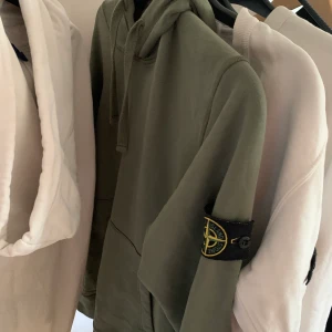Stone island hoddie  - Det är en grön stone island hoddie som är i stl L och är 8,5/10 men sparsamt och försiktigt andvänd.                            Tar även emot bud och trades om det är intressant