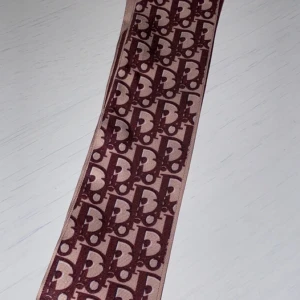 DIOR mini scarf/hårband/väskaccessoar - Helt oanvänd, jättefin att ha i håret eller på väskan☺️ säljer för att den tyvärr ej kommer till användning och säkerligen skulle uppskattas av någon annan ❤️  ej äkta, riktiga går för 2000-3000
