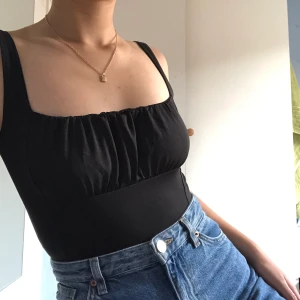 Svart croptop - En trendig svart croptop i lent och fint material som är helt ny och oanvänd. 