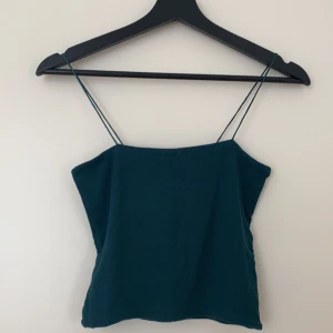 Linne Bikbok - Ett ribbat linne med smala band från bikbok i en mörkgrön färg. Storlek XS. Använt några gånger, bra skick. Fraktkostnad tillkommer.