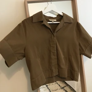 Cropped skjorta Whyred brun/grön - Cropped kortärmad skjorta från Whyred storlek S, sjukt snygg med highwaisted byxor, tyvärr för stor för mig använd 3-4gånger