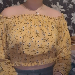 Gul off-shoulder blus med blomderaljer  - Väldigt fin och söt. Sitter skönt. Använd max 2 gånger. Fin att ha på sommaren 