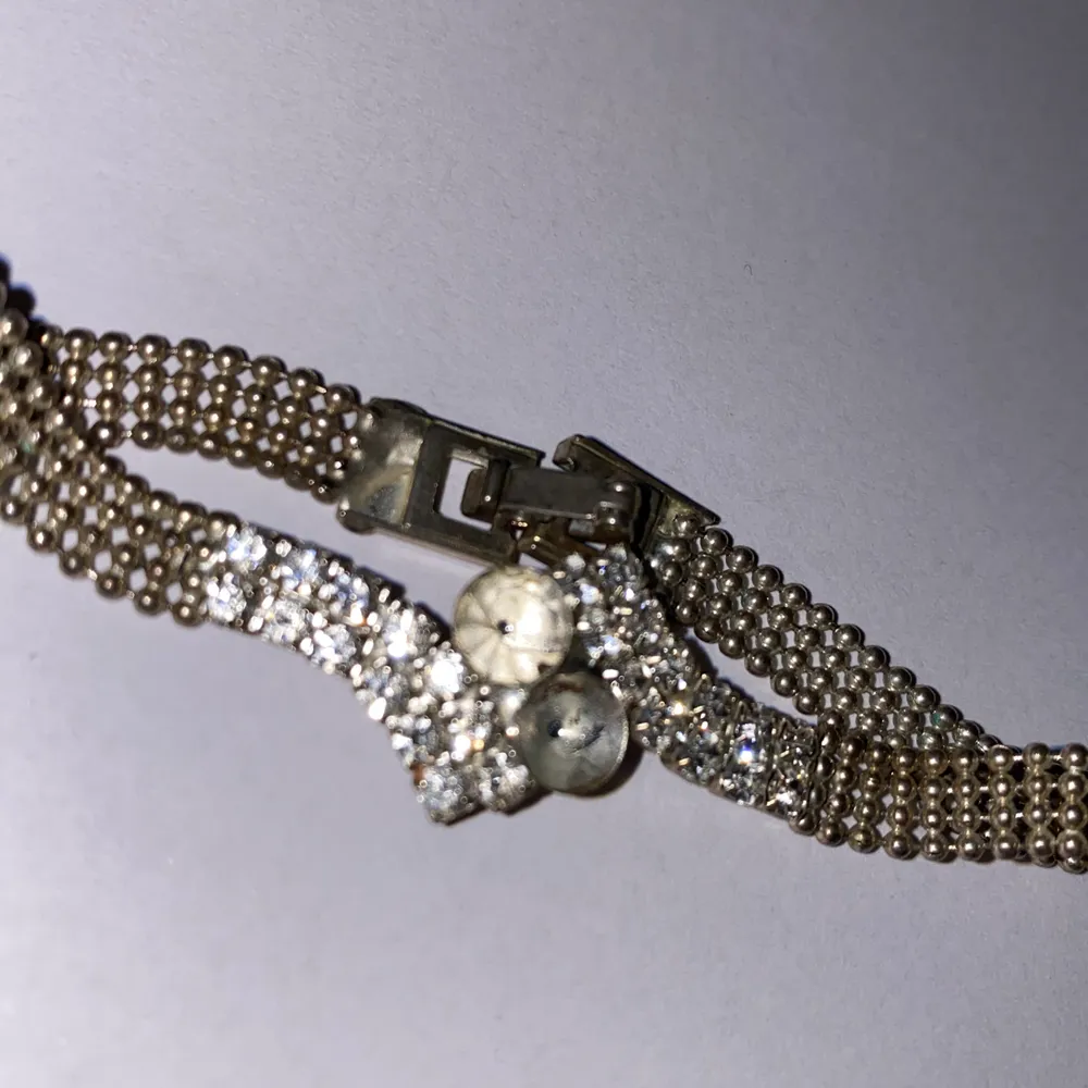 Ett armband som har tappt två ”diamanter” i mitten men den ser fortfarande fin ut. Accessoarer.