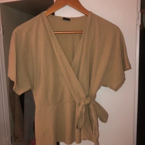 Topp från ginatricot - En super gullig liten topp från ginatricot med knytning på sidan använd ett få tal gånger köpte den för 250kr men säljer den för 100kr då den har användts ett fåtal gånger 💗