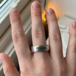 Handgjord ring i Sterling Silver. Ordet PEACE står ingraverat. Har ett spinner band. Påminner om den Harry Styles från One Direction äger. Fick den i julklapp men tyvärr passar den inte. Helt ny och oanvänd. STORLEK: 8,25 US = drygt 18,25 millimeter i diameter