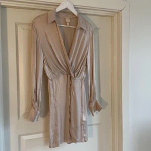 Klänning med krage - Puderrosa/ beige klänning med rynk och krage från H&M trend i strl 36. Aldrig använd.