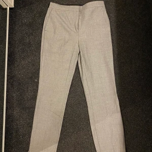 Zara kostymbyxor strl M - Gråa kostymbyxor från Zara. Sitter väldigt bra och de är i bra skick, har använt max 3 gånger. Jag är 173cm lång och de sitter perfekt i längden för mig.💜 (frakt 66kr tillkommer eller gratis upphämtning) 