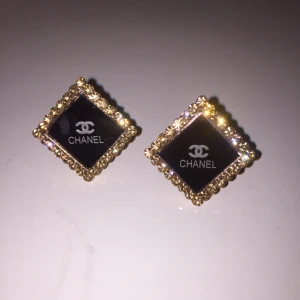  - Chanel örhängen med skimmrande stenar/strass. Oanvänd. Mått cirka 2cm