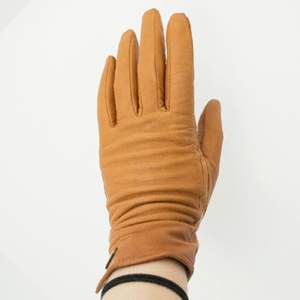 Ljusbruna handskar i fejk-skinn från H&M med små guldfärgade detaljer. 

Använda men utan större slitage.
