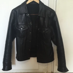  - Levi's skinnjacka i jeansjackemodell från 70-talet. Pga att den har varit med ett tag har den erhållit lite fläckar (se bild) samt att fodret är borttaget. Jag är 181 cm lång och den sitter perfekt, blandning mellan small och medium. En raritet från Levi's!