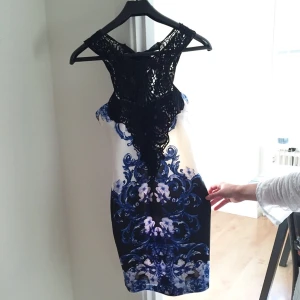  - Klänning med blåa och svarta detaljer ä, fin i rygg (bild 2). Klänningen är liten i storlek men materialet är stretchigt. 