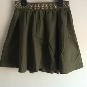 Mörkgrön kjol med guldiga detaljer med dragkedja från hm divided