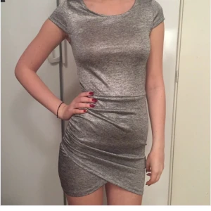  - Silvrig klänning, aldrig använd har prislappen kvar!