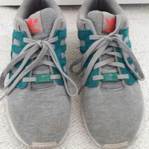  - adidas zx flux 2.0 sneakers in grey (Kind of sweater material) with blue leather stripes and bright orange/pink details. 